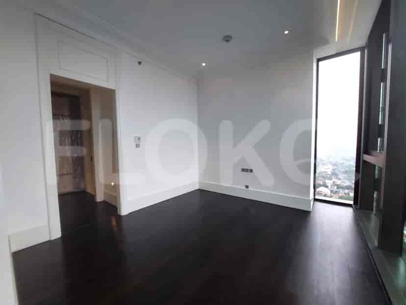 Bedroom with dark wooden floors and a large window.