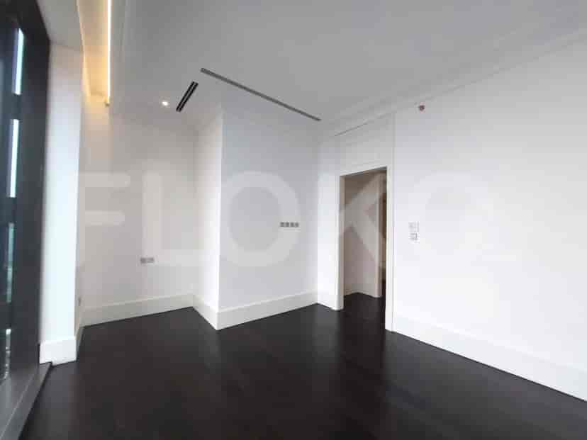 Bedroom with dark wooden floors and a large window.