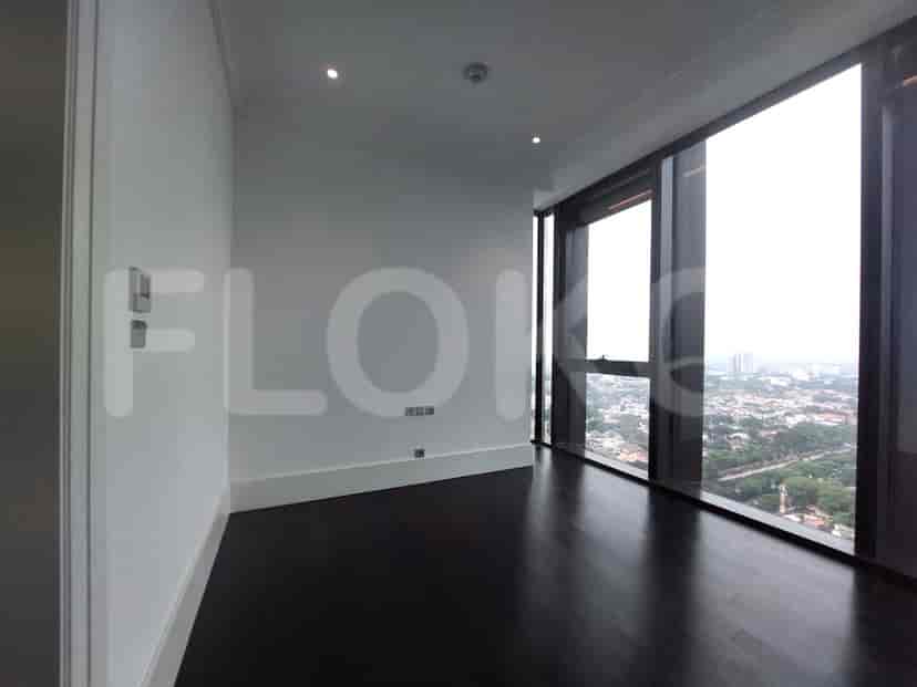 Bedroom with dark wooden floors and a large window.