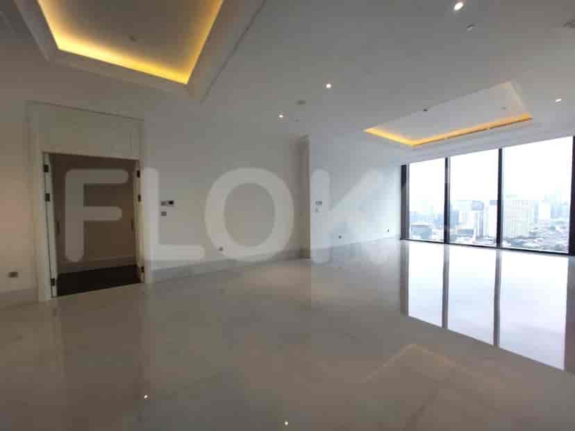 Empty living room with large windows and city view.