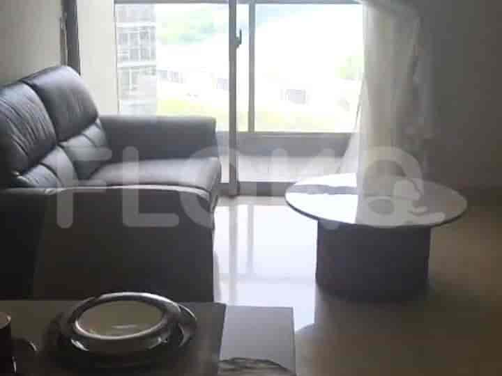 Modern living room with leather sofa, round coffee table, and large window.
