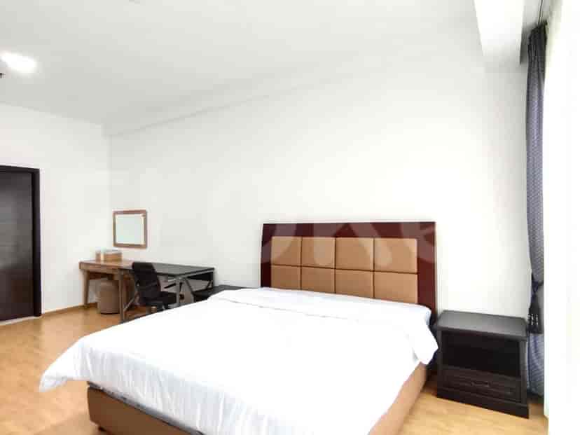 A bedroom with a double bed, wooden desk, and neutral color scheme.