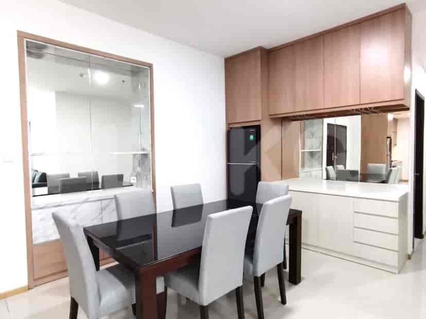 A dining area with a dark wood table, seating six, and a mirrored wall.