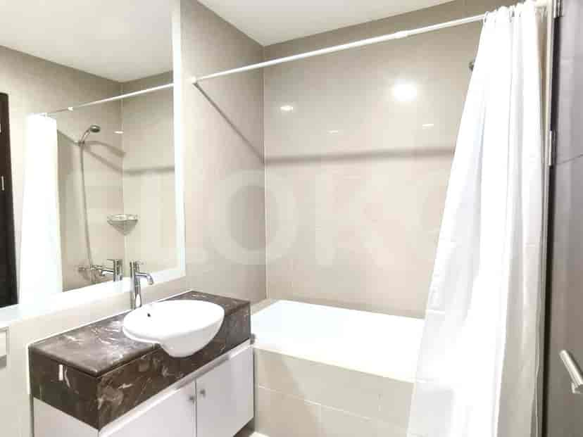 A bathroom with a bathtub, a sink, and a large mirror.