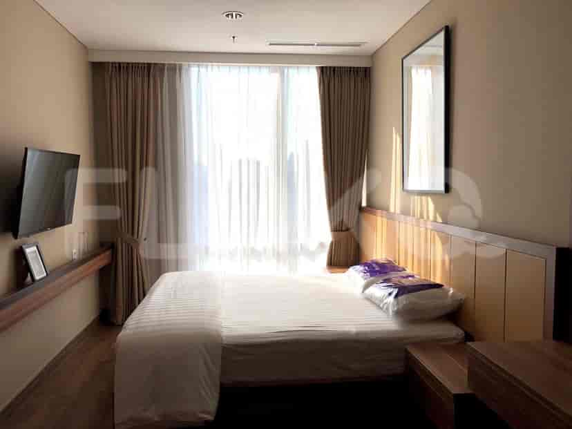 Kamar tidur dengan tempat tidur, TV, dan jendela besar.