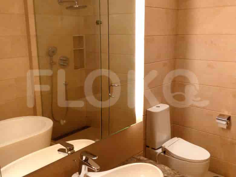 A modern bathroom with a mirror, a toilet, and a shower.