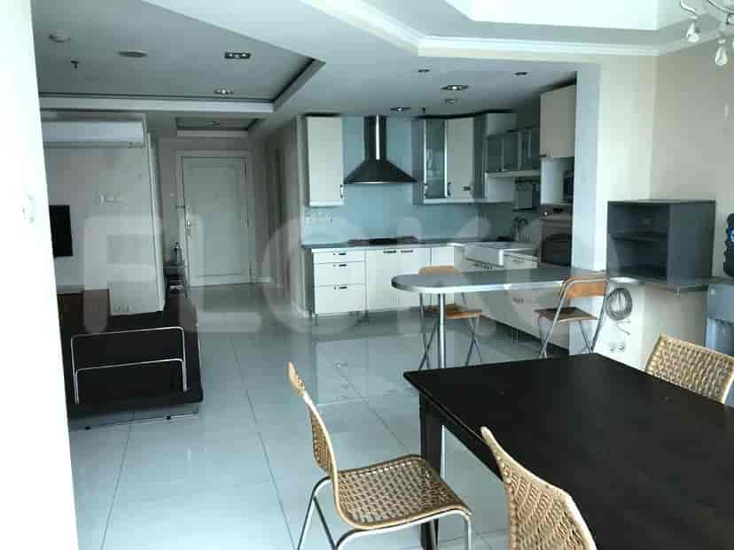 Open layout of living room and kitchen, showing dining area and appliance.