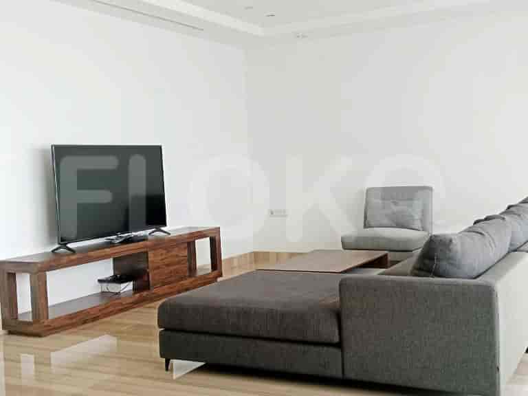 Living room with grey sofa, wooden TV stand, and a flat-screen TV.