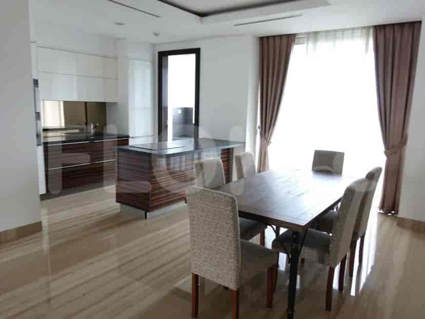Elegant dining area with a wooden dining table and stylish chairs, connected to a modern kitchen with an island.