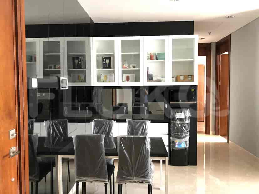 Area makan dan dapur dengan meja, lemari, dan microwave.
