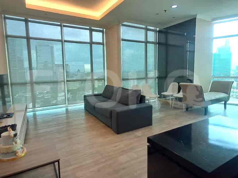 Spacious living room with a grey sofa, large windows, and city view.