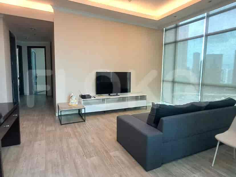 A modern living room with a TV, sofa, and large window.