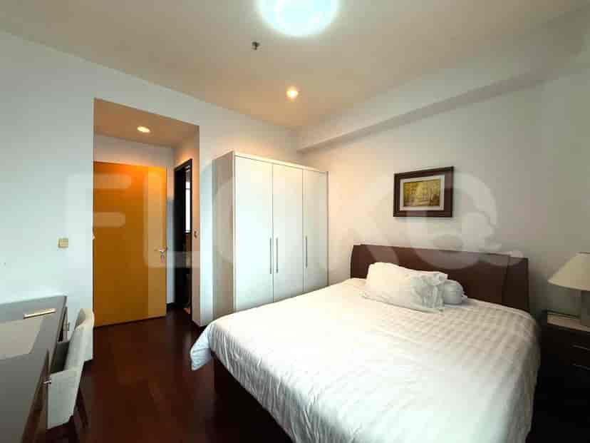 Bedroom with a queen-sized bed, wooden flooring and a white wardrobe.
