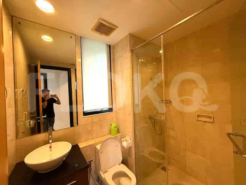 A modern bathroom with a glass-enclosed shower, a vanity with a round sink, and a toilet.