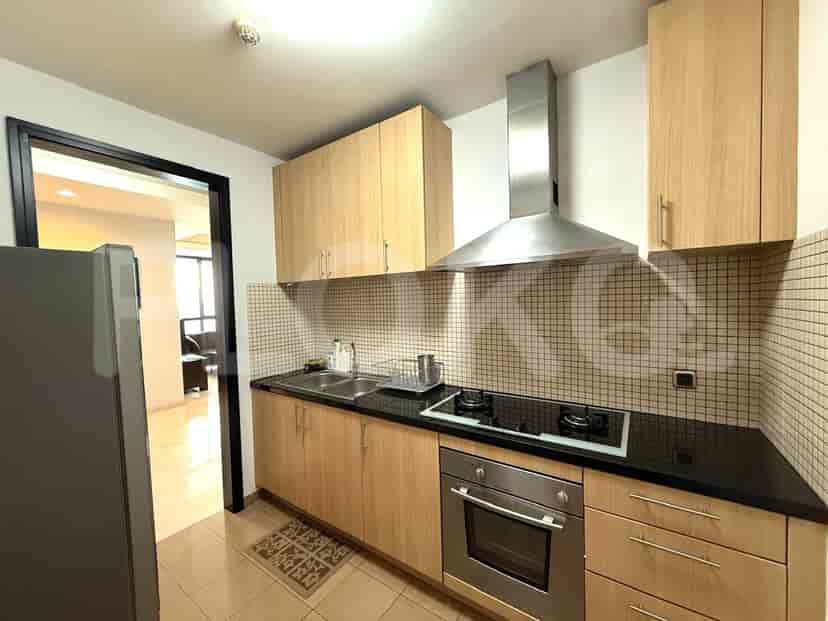 A modern kitchen with wooden cabinetry, a black countertop, and stainless steel appliances.