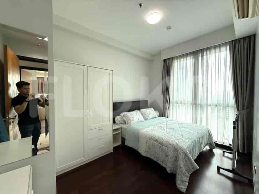 Bedroom with a bed, wardrobe, and sheer curtains.