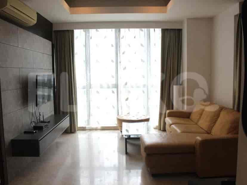 Modern living room featuring a leather sofa, floating TV console, and floor-to-ceiling windows.