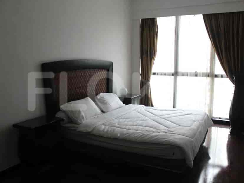 Spacious bedroom with a large bed, bedside tables, and a view overlooking outside.