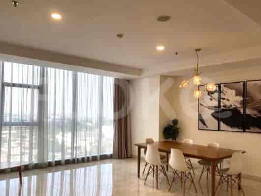 Living room with large windows and a view, showcasing a dining area and a decorative light.