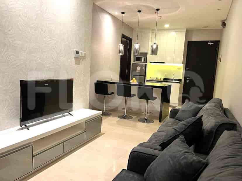 Modern living room with a kitchenette, featuring a sofa, TV, bar seating, and pendant lighting.