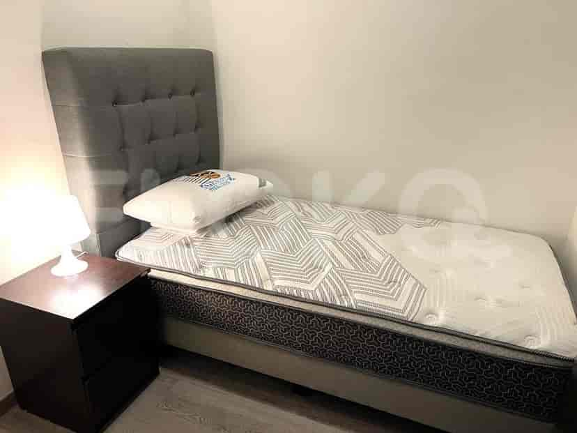 A well-lit guest bedroom with a single bed, a nightstand, and a simple design.