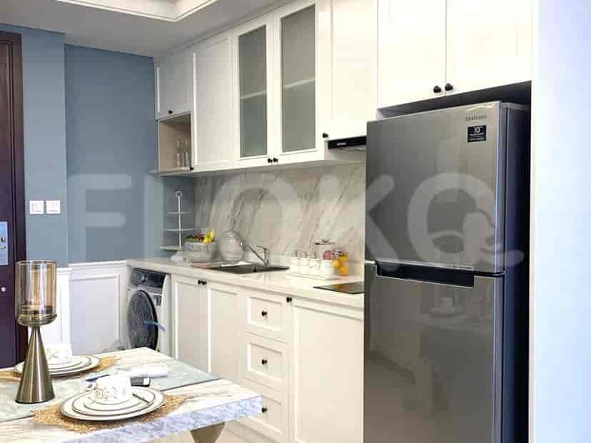 A modern kitchen with white cabinets, stainless steel appliances, and a marble countertop.