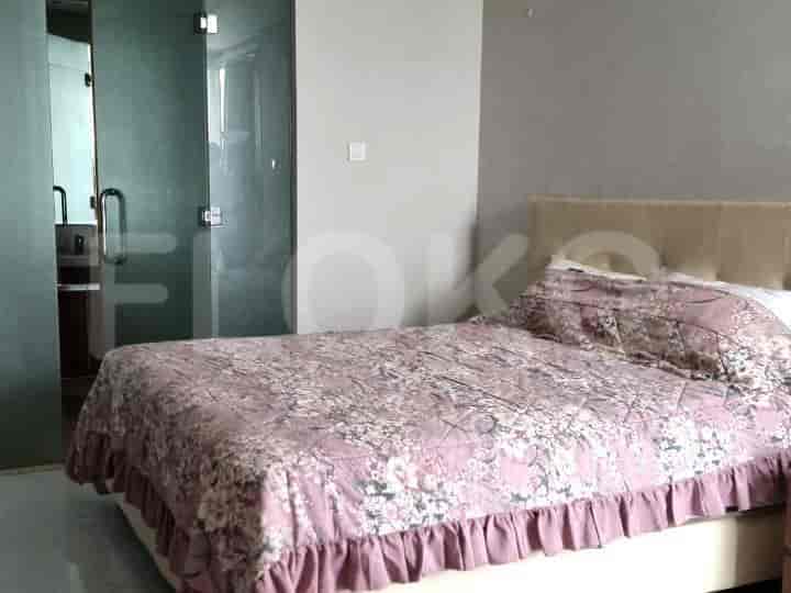 Bedroom featuring a bed with a floral bedspread, and a glass door.