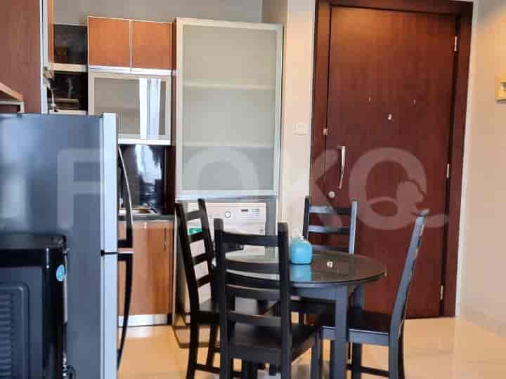 Dining area with a round black table and black chairs near kitchen.