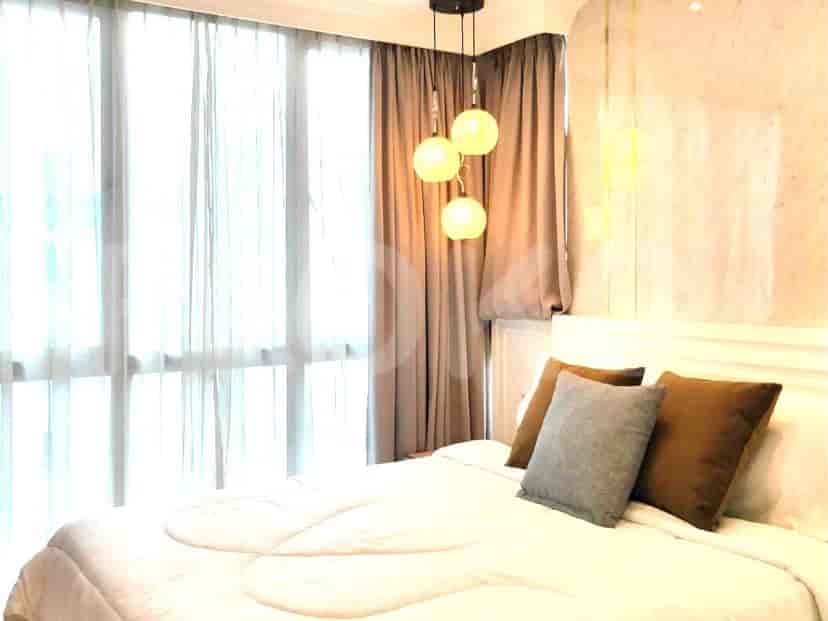A bedroom featuring a bed, curtains, and a lamp.