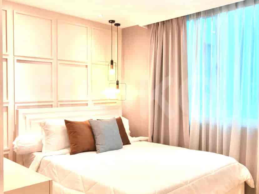 A bedroom featuring a bed, curtains, and a lamp.