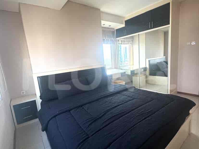 Kamar tidur yang menampilkan tempat tidur dengan linen hitam, cermin, dan meja tulis.
