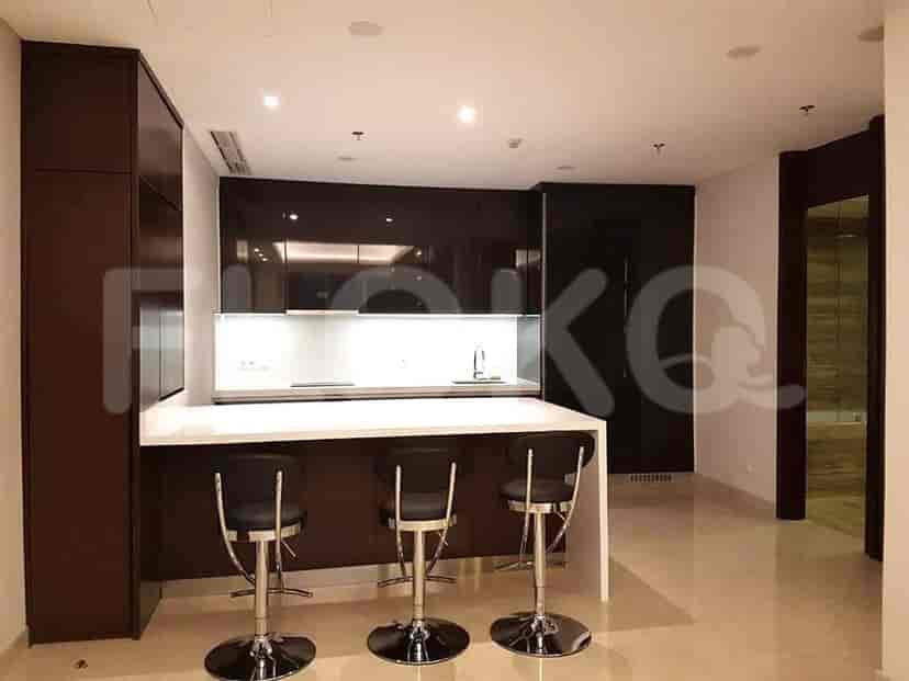 Modern kitchen with dark cabinets, a white countertop, and bar stools.