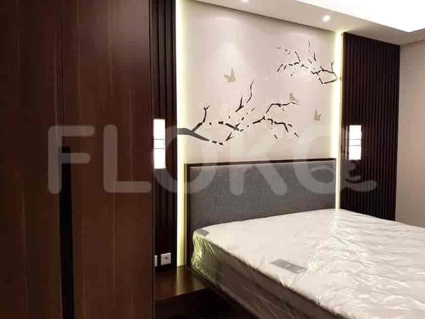 A well-lit bedroom with a bed, wardrobe, and artistic wall decor.