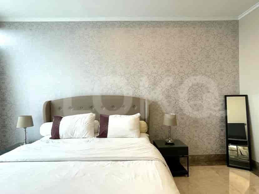 A cozy bedroom featuring a bed, bedside tables, and a decorative wall.