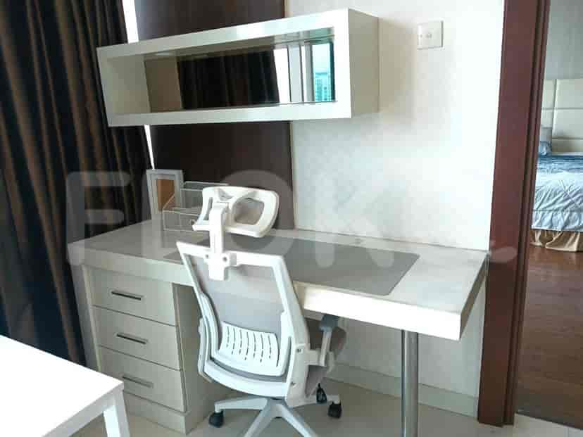 A study/office area with a desk, a chair, and an overhead shelf.