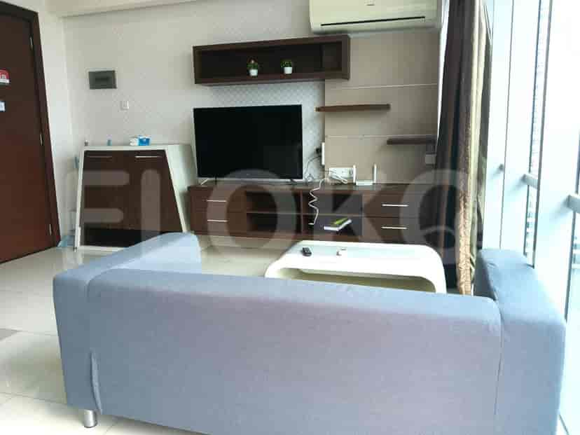 Living room with a large TV, white coffee table, and grey sofa.