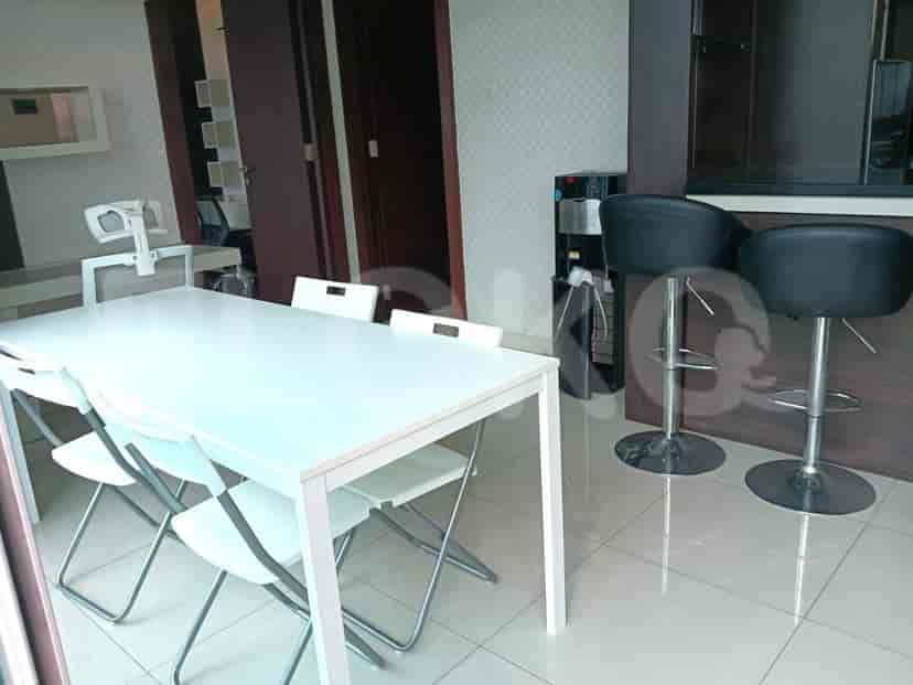 Dining area with a white table and chairs and bar stools.