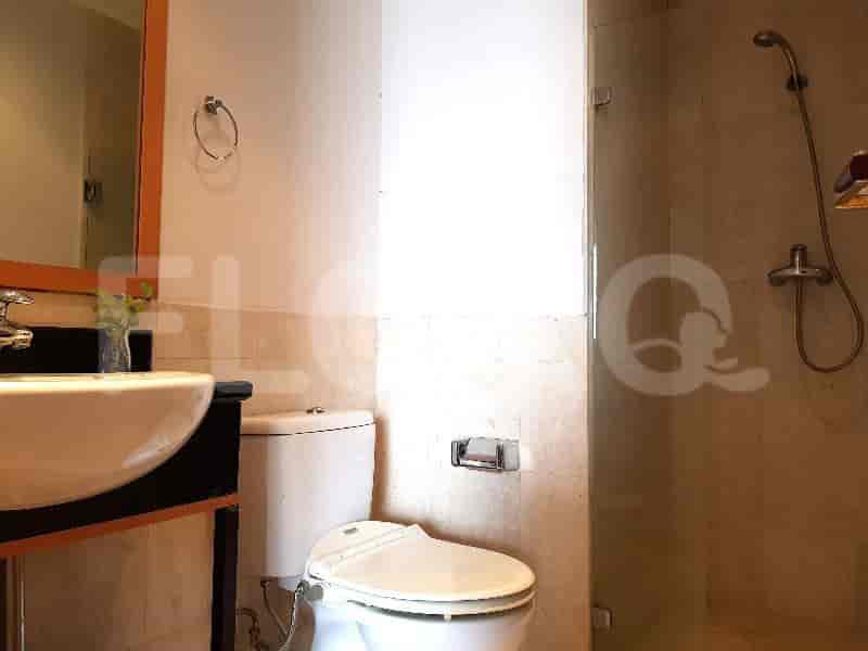 A modern bathroom with a toilet, sink, and a glass-enclosed shower.