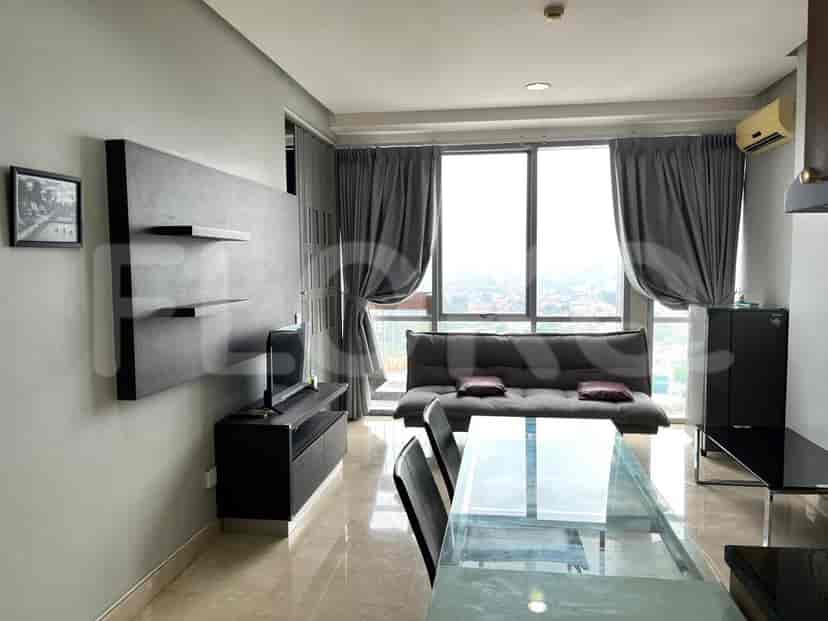 Modern living room with a sofa, entertainment unit, and large windows.