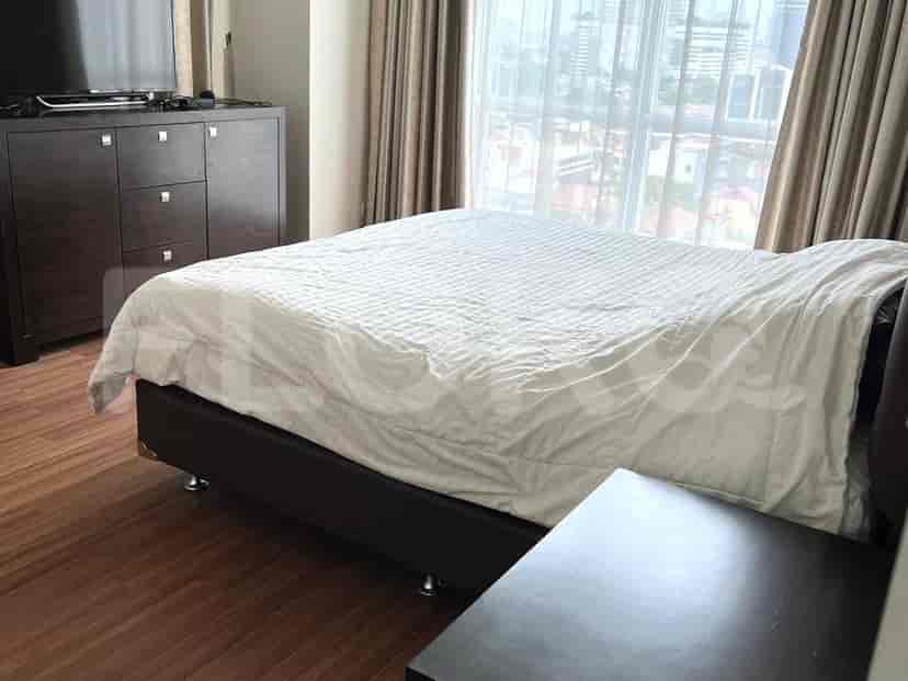 A bedroom showcasing a large bed with a white duvet and a dark-colored dresser.