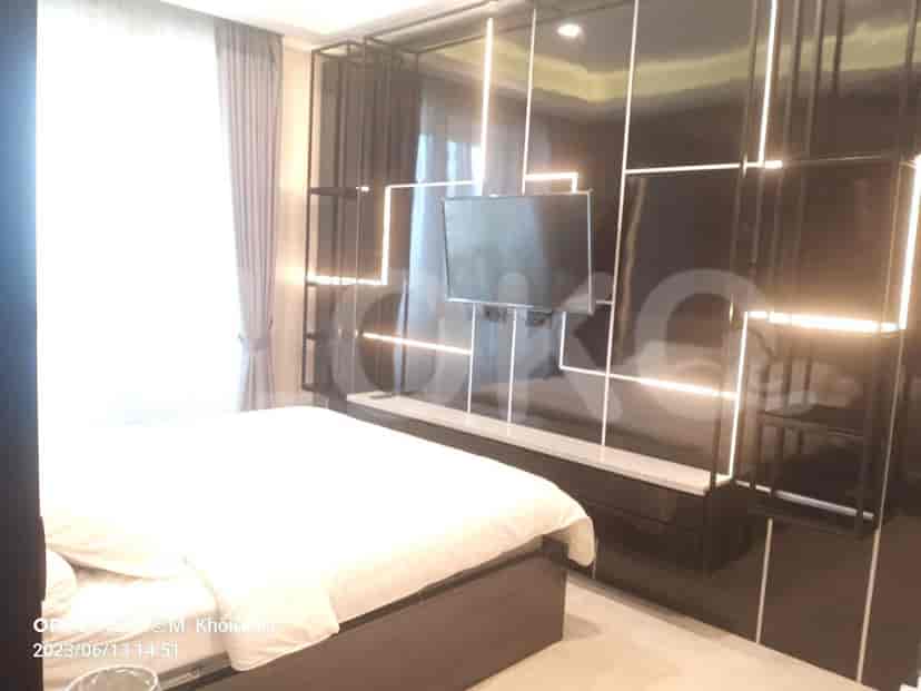 Modern bedroom featuring a bed, wall-mounted TV, and a combination of black and white decor.