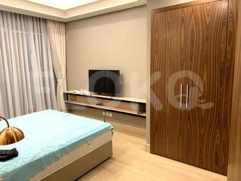 A bedroom featuring a bed, TV, and wooden wardrobe.