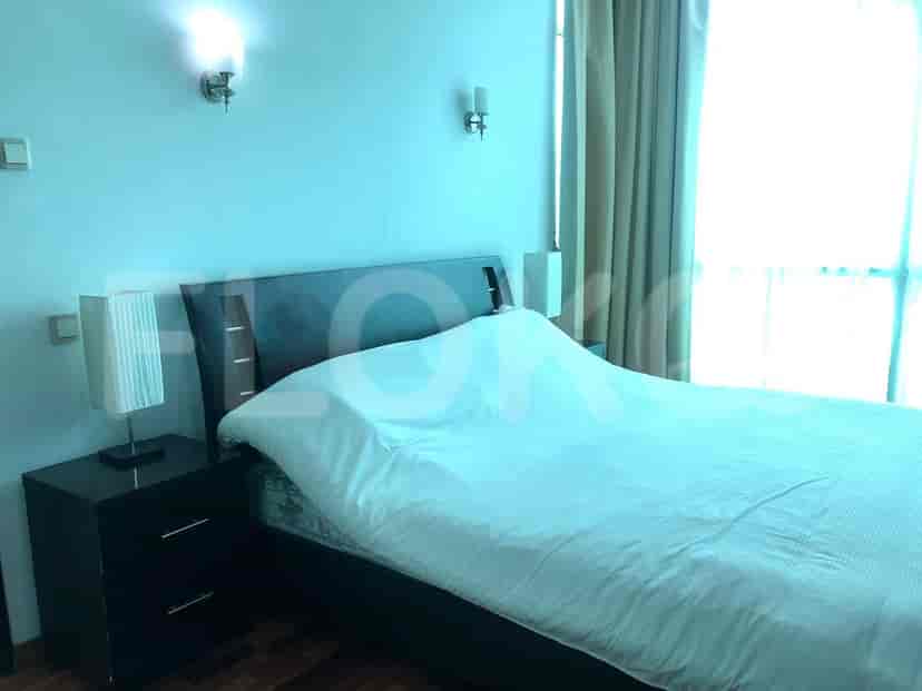 A bedroom with a bed and lamps.
