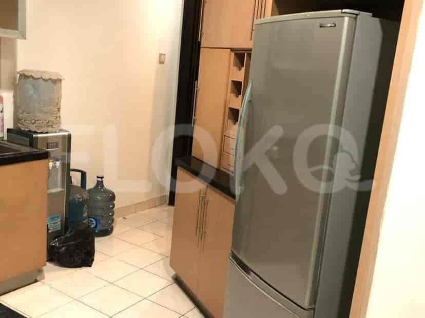 A kitchen with a refrigerator, cabinets, and water dispensers.