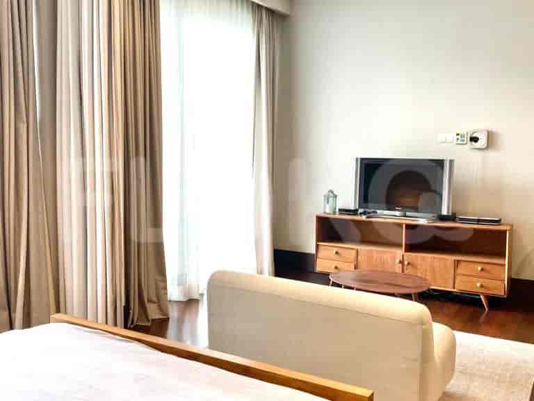Bedroom with a bed, TV, and wooden furniture.