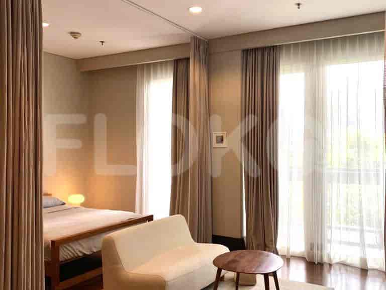 Bedroom with a bed, curtains, and a small table.