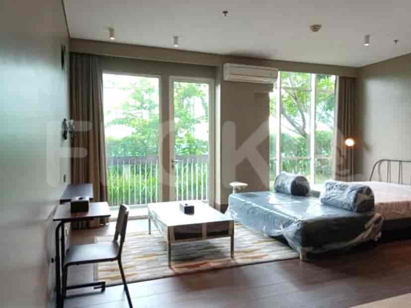 Modern studio apartment with a living area, balcony access, and partial views.