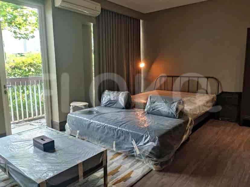 View of the living area with sofa, coffee table, and bed.