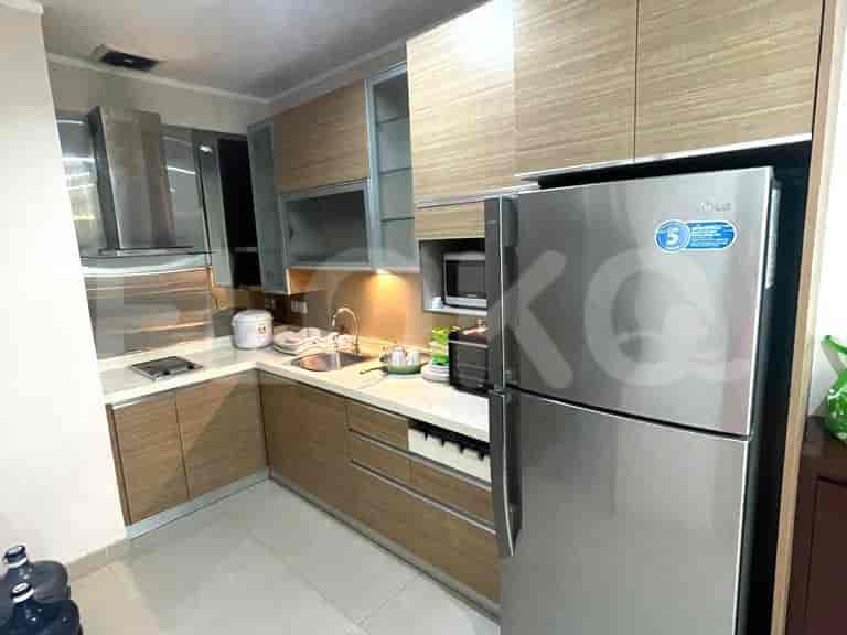 A modern kitchen with wooden cabinets, stainless steel appliances, and a refrigerator.
