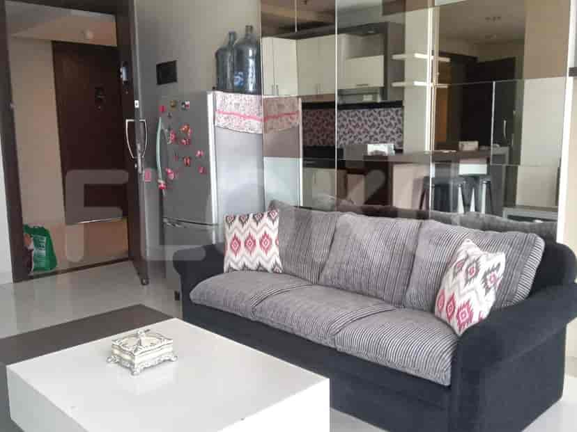 Living room with grey sofa, coffee table, refrigerator, and mirrored wall.